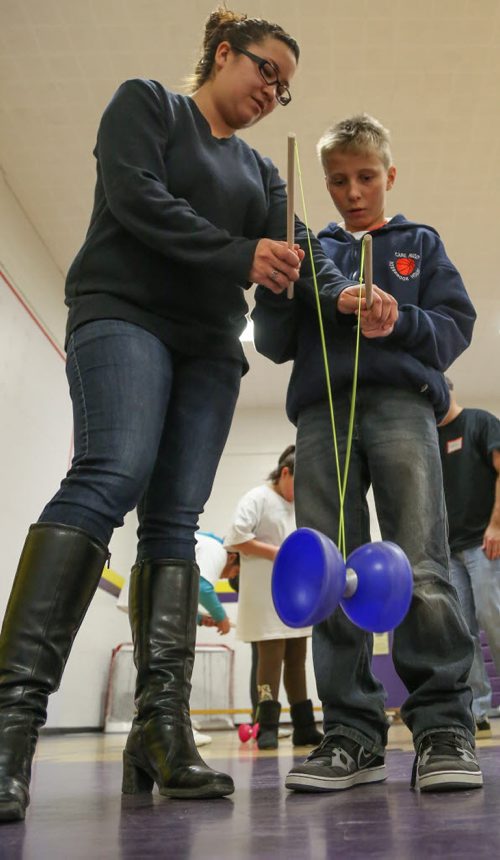 Brady McNabb, 11, right, puts a new spin on things as he learns to use diablo sticks, with the guidance of Roxanne Ballantyne, at the 17th annual Circus and Magic Partnership (C.A.M.P) at Gordon Bell High School in Winnipeg on Tuesday, April 1, 2014. C.A.M.P is an artistic intervention project for at-risk kids, spearheaded by the Winnipeg International Children's Festival . (Photo by Crystal Schick/Winnipeg Free Press)