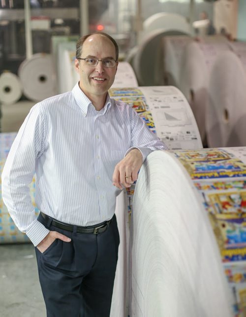 John Pollard, co-CEO of Pollard Banknote Limited, poses against a roll of instant-win lottery tickets at the printing plant in Winnipeg on Wednesday, April 2, 2014. The company is rolling out new initiatives which will allow them to expand their already world-class business. (Photo by Crystal Schick/Winnipeg Free Press)