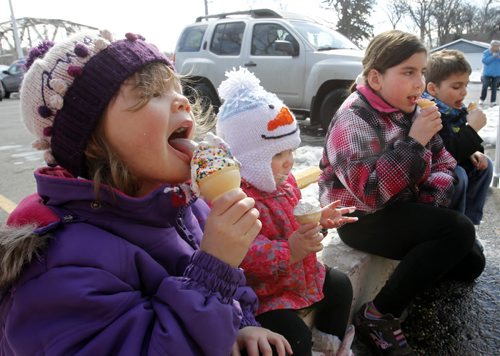 From left Danika,3, and sister Deah, 18 mos. beside Austyn,8, and her brother Thayne,6, sit on a curb at the BDI Friday afternoon and enjoy their first ice cream of the year at the popular ice cream location.   For weather story.  Wayne Glowacki / Winnipeg Free Press April 4   2014