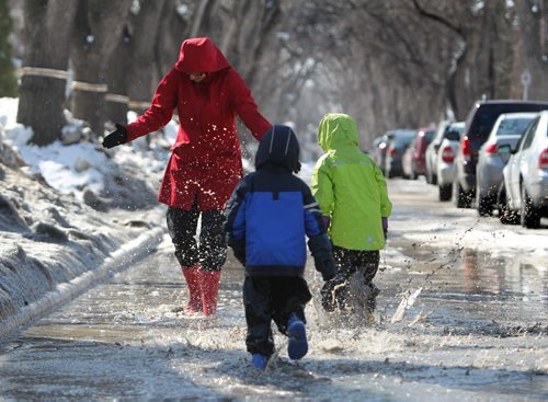 Six year old Anika Durksen and her little brother Felix - 3yrs  splash their mom while playing in a puddle on their way to the store  Saturday in Wolsely.  Standup Photo April 05, 2014 Ruth Bonneville / Winnipeg Free Press