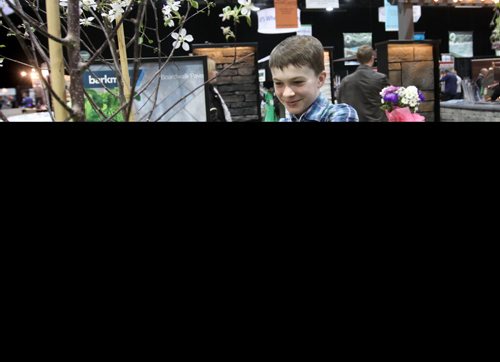 Twelve year old Matthew Trudeau takes pictures of a plant display at the Home Expression Show at the Convention Centre Saturday in hopes of planting a garden with his mom this spring.  Standup photo  April 05,  2014 Ruth Bonneville / Winnipeg Free Press
