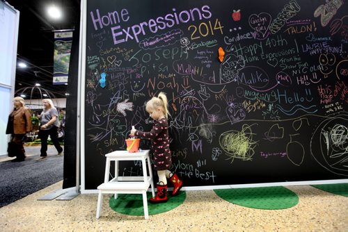 Three year old Emily Neufeld  draws on a giant black board on display at the  Home Expression Show at the Convention Centre Saturday. See story.   April 05,  2014 Ruth Bonneville / Winnipeg Free Press