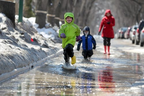 Six year old Anika Durksen runes through a large puddle on Evanson Street with her little brother Felix - 3yrs   on their way to the store with mom Saturday .  Standup Photo April 05, 2014 Ruth Bonneville / Winnipeg Free Press