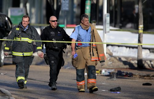 Responders and Police walk past a persons belongings near the corner of Broadway and Donald after a pedestrian was struck by a vehicle, Saturday, April 5, 2014. (TREVOR HAGAN/WINNIPEG FREE PRESS)