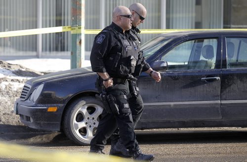 Police walk past a car believed to be involved after a pedestrian was struck at Broadway and Donald, Saturday, April 5, 2014. (TREVOR HAGAN/WINNIPEG FREE PRESS)