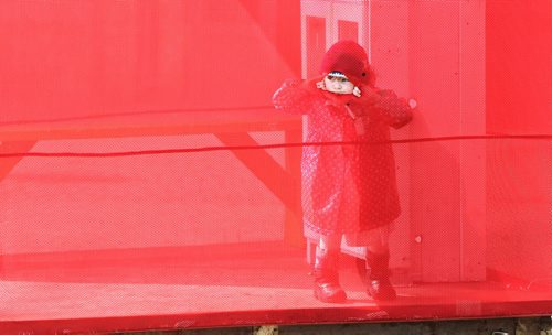 Nieve Freeman, 3, peeks through the mesh screen that encloses the Little Free Library at The Forks Sunday afternoon.  140406 April 06, 2014 Mike Deal / Winnipeg Free Press