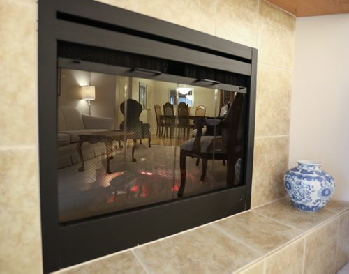 105-93 Swindon Way fireplace with living room and dining room reflection in Winnipeg on Monday, April 7, 2014. (Photo by Crystal Schick/Winnipeg Free Press)