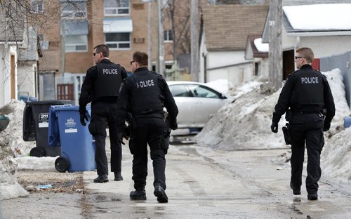 Winnipeg Police have swarmed an area  around Manitoba Ave and McKenzie St , the scene of an apparent shooting  , police are patrolling the area  checking lane ways in the area . April 7 2014 / KEN GIGLIOTTI / WINNIPEG FREE PRESS
