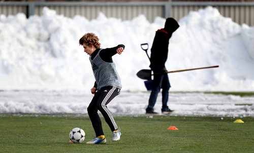 Hoodies and sweats were the in fashion as young soccer players jockey for position on teams for the upcoming season during tryouts at the WInnipeg Soccer Complex Monday evening.Volunteers shoveled snow off the field behind the scene. See story. April 7, 2014 - (Phil Hossack / Winnipeg Free Press)