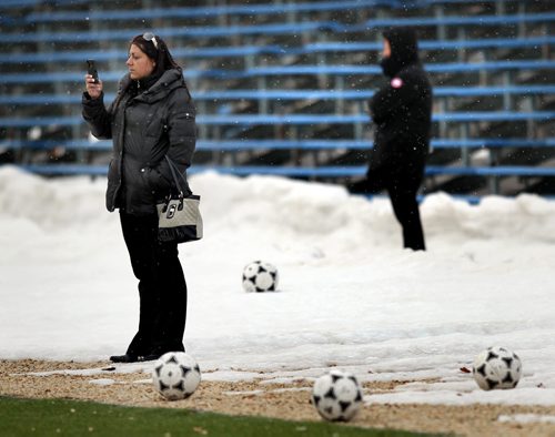 Parents prepare their facebok postings from snow covered sidelines Monday at the WInnipeg Soccer Complex as their children jockey for position on teams for the upcoming season. See story. April 7, 2014 - (Phil Hossack / Winnipeg Free Press)