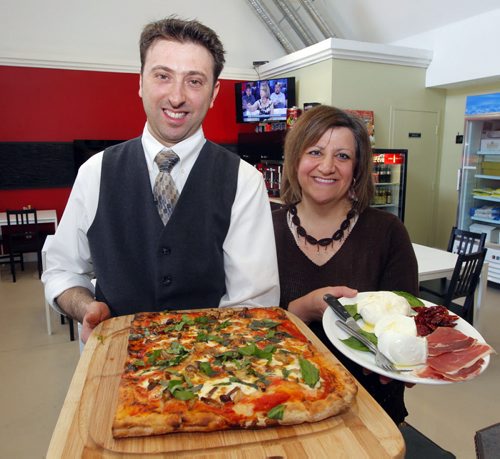 Restaurant review - Cafferia 360. (L)Massimo Buono and (R)Donna Casale pose for a photo in their newly expanded restaurant on Corydon. Massimo holds the fungi pizza and Donna holds a special Italian Burrato, Mozzarella di Bufala and Red peppers cruschi from Basilicapa, Southern Italy. BORIS MINKEVICH / WINNIPEG FREE PRESS April 8, 2014