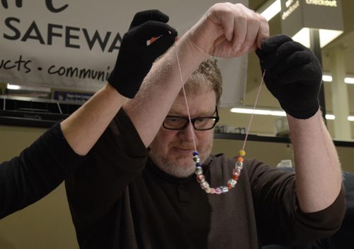 Doug Speirs beads a necklace at the Easter Seals SMD Foundation media event at Safeway Osborne Village.  The motto of the event was to find ability in disability through inclusive camp model.  EMILY CUMMING / WINNIPEG FREE PRESS APRIL 8, 2014