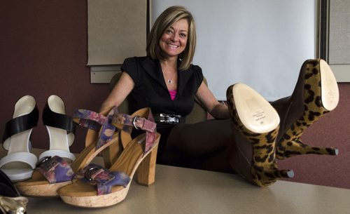 Trish Taylor, Community Partnership & Events Manager for the Heart & Stroke Foundation, tries on a pair of shoes in advance of the shoe auction. EMILY CUMMING / WINNIPEG FREE PRESS APRIL 9, 2014