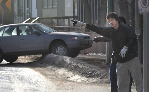 While waiting for a tow, Freddie Kwok at right and his son Fred alert traffic on an icy curve on Broadway near Portage Ave. that resulted in Fred's car sliding over the curb. Wayne Glowacki / Winnipeg Free Press April 11   2014