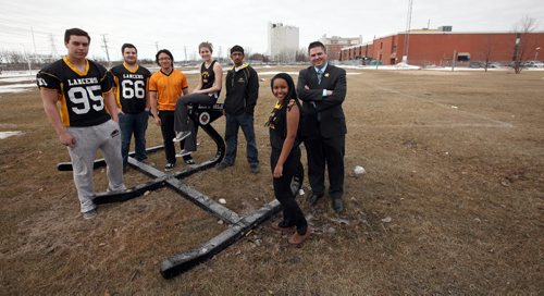Left to right Derek Dufault, Austin Patterson, Chris Mar, Erin White, Amitesh Galhotra and Mahilet Meshesha students at Dakota Collegiate pose with vice principal Robbie Mager on their athletic field they are holding fundraisers to cover with astro-turf. See Nick Martin story. April 11, 2014 - (Phil Hossack / Winnipeg Free Press)