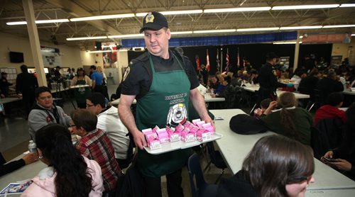 "To Serve and Protect" er serve.....Cst Pat Remillard passes out pints of milk Friday afternoon at the 18th ANNUAL Winnipeg Police Service NORTH END SPRING FEAST. The six year old also is one of William Whyte's star square dancers. See release April 11, 2014 - (Phil Hossack / Winnipeg Free Press)