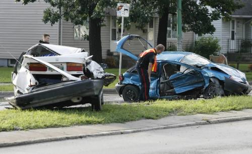 John Woods / Winnipeg Free Press / July 1/07- 070701  - A police officer inspects an MVA on Kenaston just south of Corydon July 1/07.