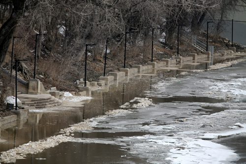 The Assiniboine River threatens lamp posts that line the already submerged walking path, as seen from the Midtown Bridge, Sunday, April 13, 2014. (TREVOR HAGAN/WINNIPEG FREE PRESS)