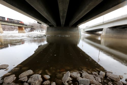 Assiniboine River water passes under the Main Street Bridge and threatens to cover the remaining sections of the walking path at The Forks, Sunday, April 13, 2014. (TREVOR HAGAN/WINNIPEG FREE PRESS)