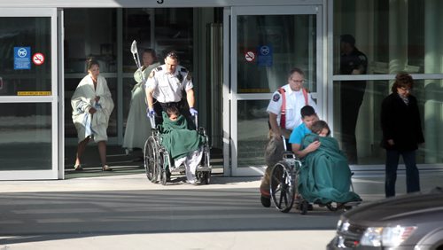 Emergency vehicles including MERV (Major Incident Response Vehicle) converged in the departure lanes in front of James Richardson Intl Airport Monday. Here five of six (one in a blanket behind the second paramedic pushing a wheelchair) patients are moved out and placed in the MERV. See story. April 14, 2014 - (Phil Hossack / Winnipeg Free Press)