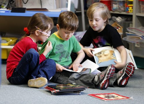 49.8 Popularity of French  Immersion .Photos taken at Ecole Julie-Riel  . Gr1 ,LtoR , Evania  Diaz- Rojas , Carter Hafenbrak , and Jake Brocklehurst read book together  . Story by Nick Martin .  April 15 2014 / KEN GIGLIOTTI / WINNIPEG FREE PRESS