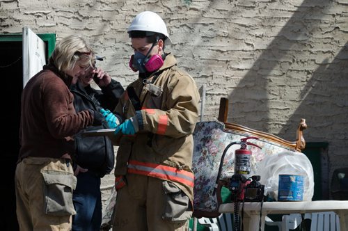 Fire officials stand outside of a home on the 300 block of Enfield Crescent near Marion Street.  The basement resident died as a result of the fire.  The cause of the early morning fire is under investigation.  EMILY CUMMING / WINNIPEG FREE PRESS APRIL 16, 2014