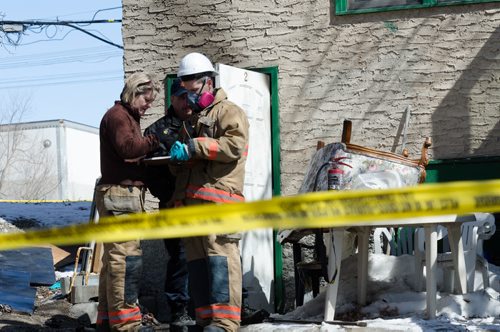 Fire officials stand outside of a home on the 300 block of Enfield Crescent near Marion Street.  The basement resident died as a result of the fire.  The cause of the early morning fire is under investigation.  EMILY CUMMING / WINNIPEG FREE PRESS APRIL 16, 2014