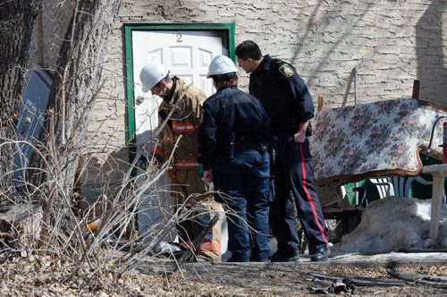 A fire official and police officers examine the door of a home on the 300 block of Enfield Crescent near Marion Street.  The basement resident died as a result of the fire.  The cause of the early morning fire is under investigation.  EMILY CUMMING / WINNIPEG FREE PRESS APRIL 16, 2014