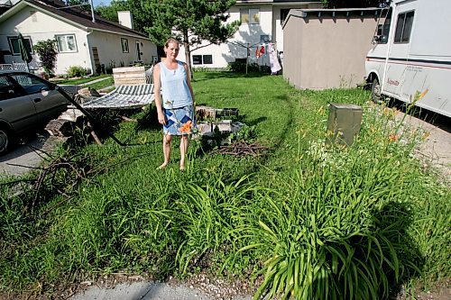 BORIS MINKEVICH / WINNIPEG FREE PRESS  070702 Melanie Meade stands where she says there should be a fence in back yard of her south winnipeg side by side.