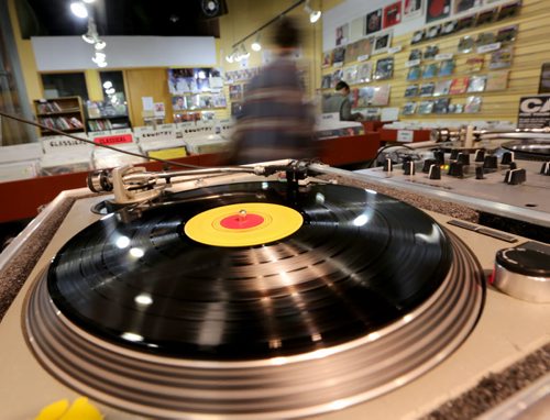 Dane Goulet, aka Birdapres spins on the turntables while people shop in Into the Music on McDermot Avenue on Record Store Day, Saturday, April 19, 2014. (TREVOR HAGAN/WINNIPEG FREE PRESS)