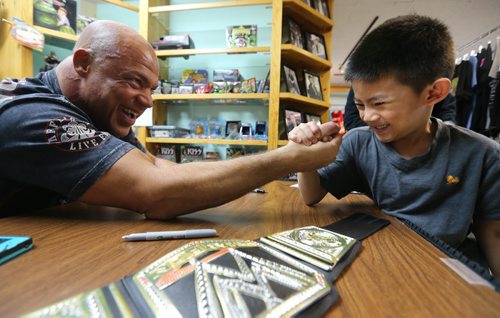 Wrestler Kurt Angle is beat in an arm wrestle by Jathan Closas, 6, at Primos Collectables in Garden City Shopping Centre, Saturday, April 19, 2014. (TREVOR HAGAN/WINNIPEG FREE PRESS) - NOTE: JATHAN IS CORRECT SPELLING