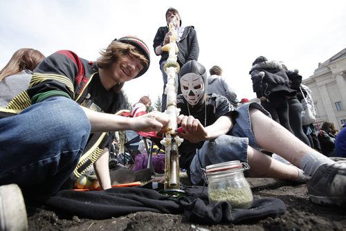 April 20, 2014 - 140420  -  Robert, Justin and Kodi enjoy a supersize seven foot bong during today's gathering at the Manitoba Legislature Sunday, April 20, 2014. People gathered to enjoy some pot and protest Canada's marijuana laws on the grounds without interference from police. John Woods / Winnipeg Free Press