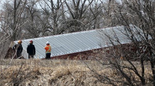 Firefighters speak with a CN Rail employee at the scene after a few cars derailed on a section of track next to Pembina Highway in St.Norbert, Sunday, April 20, 2014. There were no injuries, and the contents pose no environmental risk. (WINNIPEG FREE PRESS)
