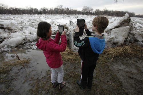 April 20, 2014 - 140420  -  Sarah and her brother Owen were out recording the ice flow on the Red River Sunday, April 20, 2014. John Woods / Winnipeg Free Press