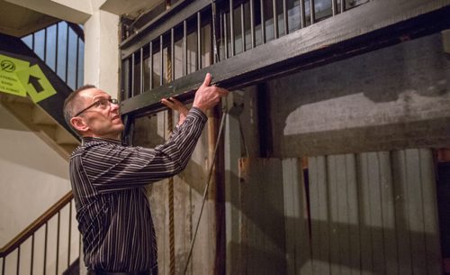Kevin Donnelly, senior vice president of venues and entertainment of True North Sports and Entertainment, demonstrates how to use an old pulley elevator in the Burton Cummings Theatre in Winnipeg on Friday, March 21, 2014. True North is taking over the management of the theatre and has many necessary upgrades planned. (Photo by Crystal Schick/Winnipeg Free Press)