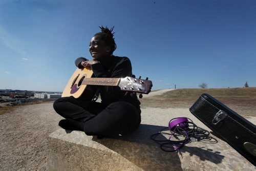 Rachel Smith took full advantage of the warmest day of the year so far to perch herself in her favourite place up on top of garbage hill and strum a few songs on her guitar while basking in the warm sunshine Tuesday afternoon. Standup Photo  April 22, 2014 Ruth Bonneville / Winnipeg Free Pres