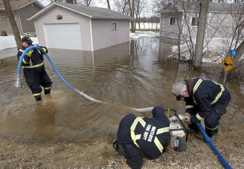 Members of the Matlock Fire Dept. prepare to pump out the water from a property on Patricia Dr. along Netley Creek Wednesday.  Residents in the area were evacuated earlier. (This was one of four properties that frequently gather water in the spring time. ) There is no water damage to any of the homes. Wayne Glowacki / Winnipeg Free Press April 23   2014