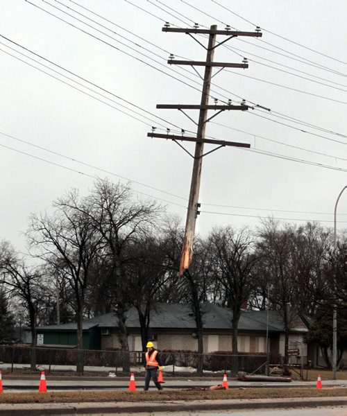 A Manitoba Hydro employee at the scene of a damaged hydro pole on the Main Street median near Templeton Ave. Thursday morning. News reports say a vehicle collided with the pole earlier closing lanes off temporarily. Wayne Glowacki / Winnipeg Free Press April 24   2014