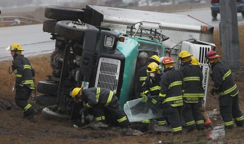 Firefighters rescue a trucker from his cab after he flipped his rig on an Eastbound off ramp near the Perimeter Hyw North at Route 90 at aprx 130PM Thursday  Breaking News- Apr 24, 2014   (JOE BRYKSA / WINNIPEG FREE PRESS)
