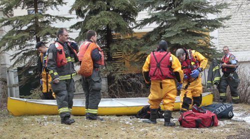 Members of the Winnipeg Fire Dept. Water Rescue unit with the canoe they plucked from the Assiniboine River near 1 Wellington Crescent Friday afternoon. The overturned canoe was seen floating in the river but no people were seen in the water. It is suspected the canoe may have been picked up upriver by the high spring water levels.   Wayne Glowacki / Winnipeg Free Press April 25   2014