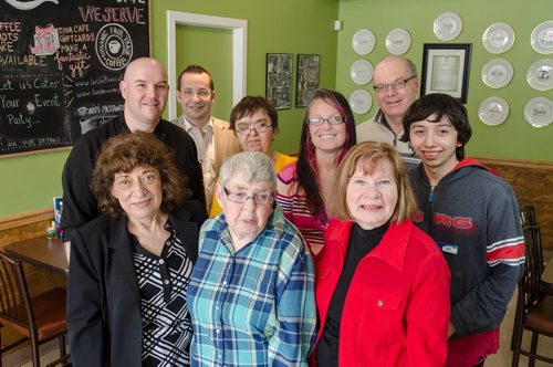 Staff pose for a photo at L'Arche Tova Cafe.  Top row from left: Chef Nick Morier, Sam Vickar, Hazel, Rachel Bobeil, Jim Lapp, Cristobal Aravena. Bottom row from left: Tova Vickar, Dorothy, Diane Truderung.  L'Arche Winnipeg, a residential home for adults with special needs, runs a cafe where some of those residents can find jobs.  EMILY CUMMING / WINNIPEG FREE PRESS
