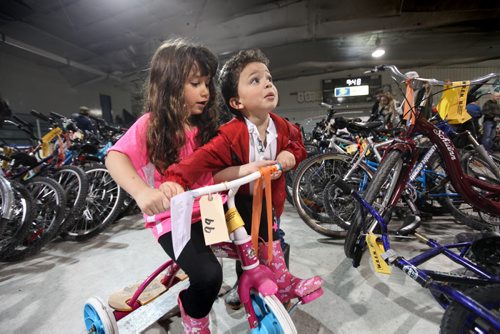 Three year old The Dixon  and his older sister Savannah - 5years jostle each other for a chance to ride one of the bikes up for auction at the city of Winnipeg's annual bike auction at Varsity View Area Saturday.  April 26, 2014 Ruth Bonneville / Winnipeg Free Pres