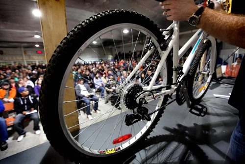 An auctioneer places one of hundreds of bikes on a table to be auctioned off in front of a large crowd attending  the city of Winnipeg's annual bike auction at Varsity View Area Saturday.  April 26, 2014 Ruth Bonneville / Winnipeg Free Pres
