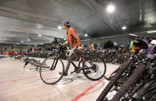 A volunteer helps move the bikes to the auctioneers table at  the city of Winnipeg's annual bike auction at Varsity View Area Saturday.  April 26, 2014 Ruth Bonneville / Winnipeg Free Pres