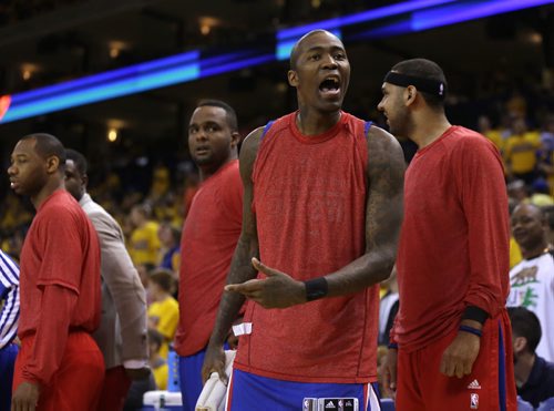 Los Angeles Clippers' Jamal Crawford, second from right, argues with a fan during the second half in Game 4 of an opening-round NBA basketball playoff series against the Golden State Warriors on Sunday, April 27, 2014, in Oakland, Calif. Clippers players wore their warmups inside out in protest of team owner Donald Sterling's alleged racial remarks. Golden State won 118-97. (AP Photo/Marcio Jose Sanchez)