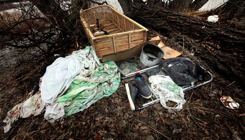 A pair of shoes sit at the foot of a wicker "bed" in a "campsite" along the Red River near Higgins ave and the river bank. April 28, 2014 - (Phil Hossack / Winnipeg Free Press)
