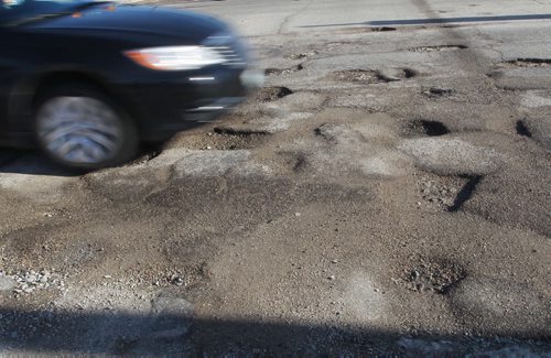 Somebody call 311   A nasty bunch of potholes have Winnipeg motorist with little choice but to drive through this cluster at Ferry Rd and Ness Ave Tuesday-Feature photo- Apr 29, 2014   (JOE BRYKSA / WINNIPEG FREE PRESS)