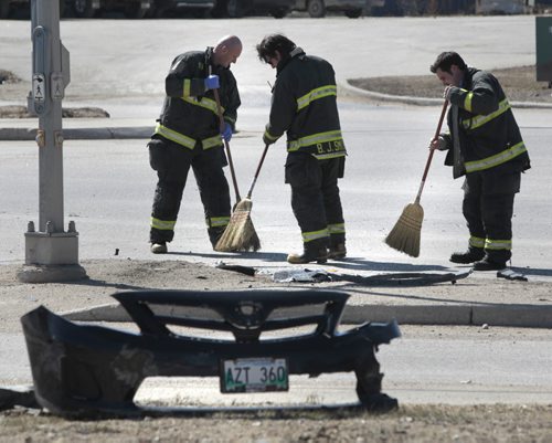 Winnipeg Fire Fighters sweep up glass and debris after a car collided with a semi-trailer at the intersection of Selkirk Ave. at Oak Point Hwy. Tuesday morning. Not sure if any injuries.  Wayne Glowacki / Winnipeg Free Press April 29   2014