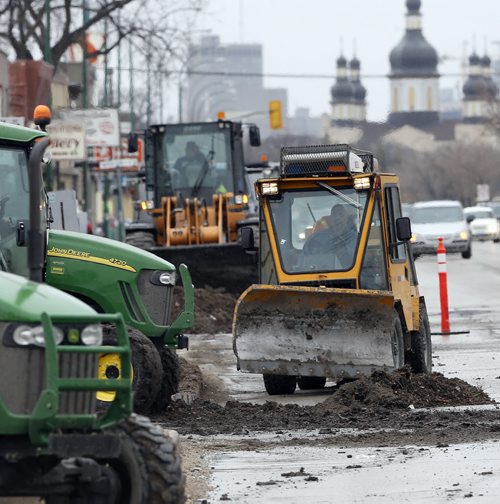 Stdup : Great Big ,Wet , dirty , city clean up continues as city crews advance along main thoroughfares  and boulevards with sweepers , front end loaders  and dump trucks picking up sand  form the winter . Crews seen on Main St. at Smithfield . APRIL 30 2014 / KEN GIGLIOTTI / WINNIPEG FREE PRESS