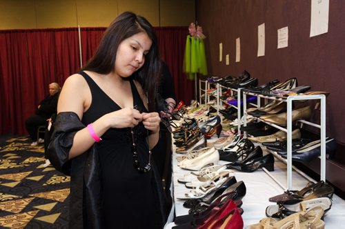 Shannon Keesickquayash, 18, looks at shoes and tries on a necklace at the Gowns for Grads program held at the convention centre.  Gowns for Grads is a volunteer program provides used and new dresses for graduation.  EMILY CUMMING / WINNIPEG FREE PRESS